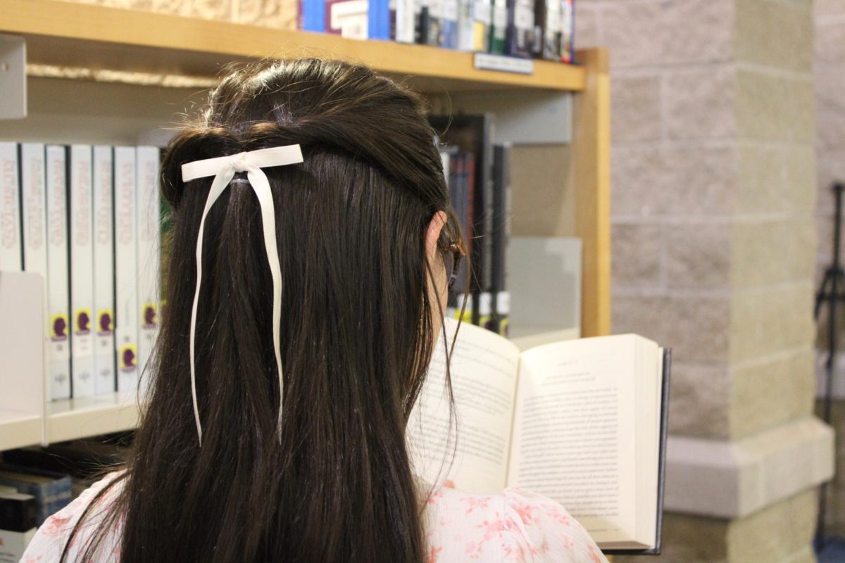 McKenna Lepage reading in the Suffield High School LMC