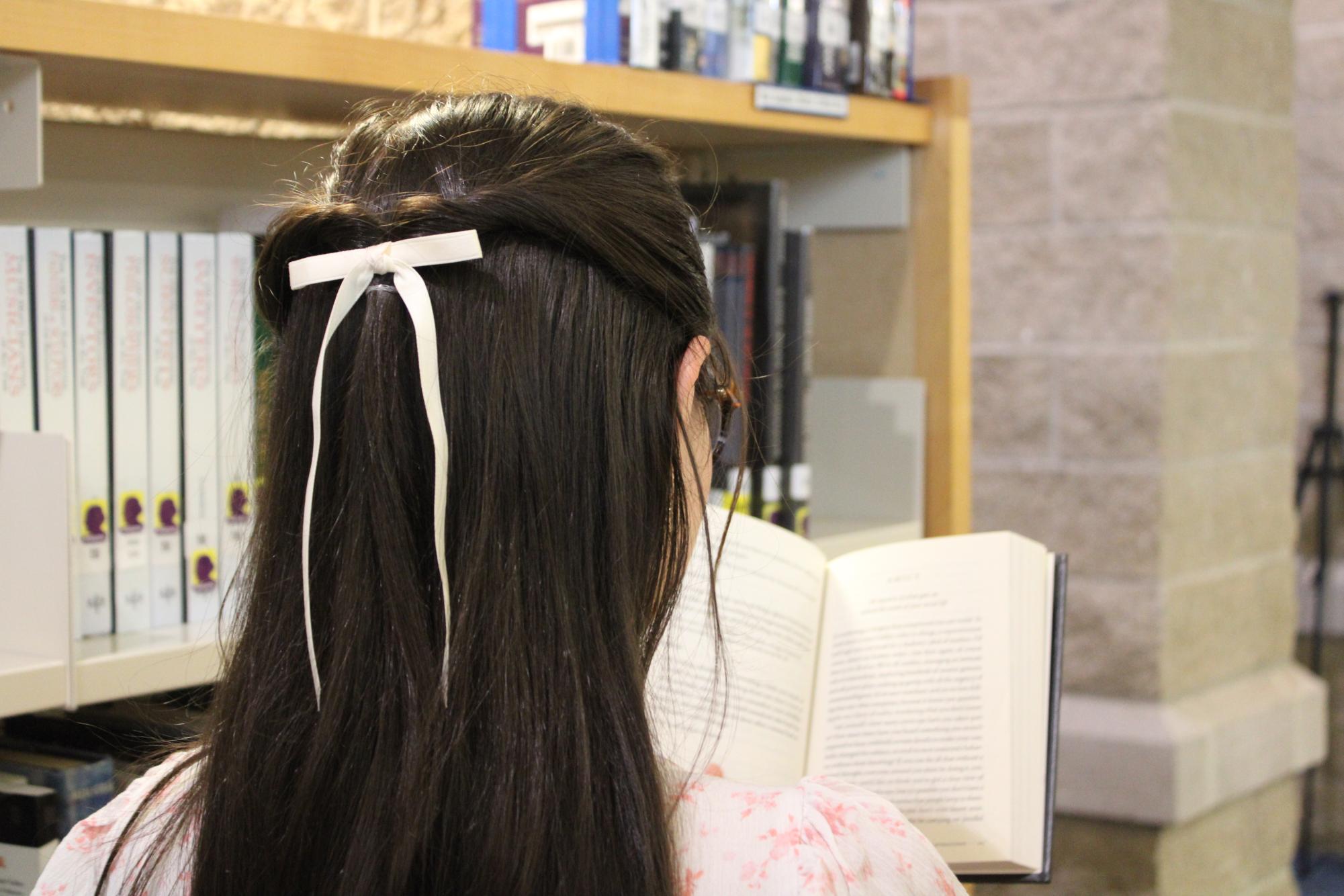 McKenna Lepage reading in the Suffield High School LMC