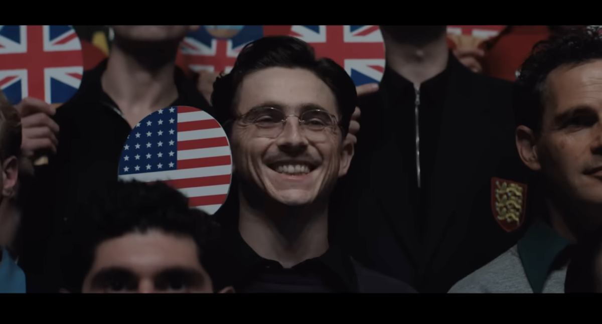 As Marty Mauser poses with the rest of the ping-pong players at the British Open, he thinks about his deservedness to succeed, a theme used throughout the film.